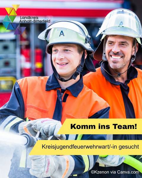 Ein Jugendlicher in Feuerwehrkleidung hat einen Wasserschlauch unterm Arm und löscht, ein älterter Feuerwehrmann steht hinter ihm und unterstützt den jungen Kameraden © Landkreis Anhalt-Bitterfeld