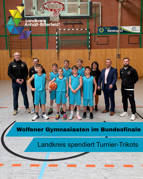 Eine Gruppe Menschen steht in einer Turnhalle, unter ihnen ein paar Jungs in leuchtend-blauen Sporthosen und -trikots. &copy; Landkreis Anhalt-Bitterfeld